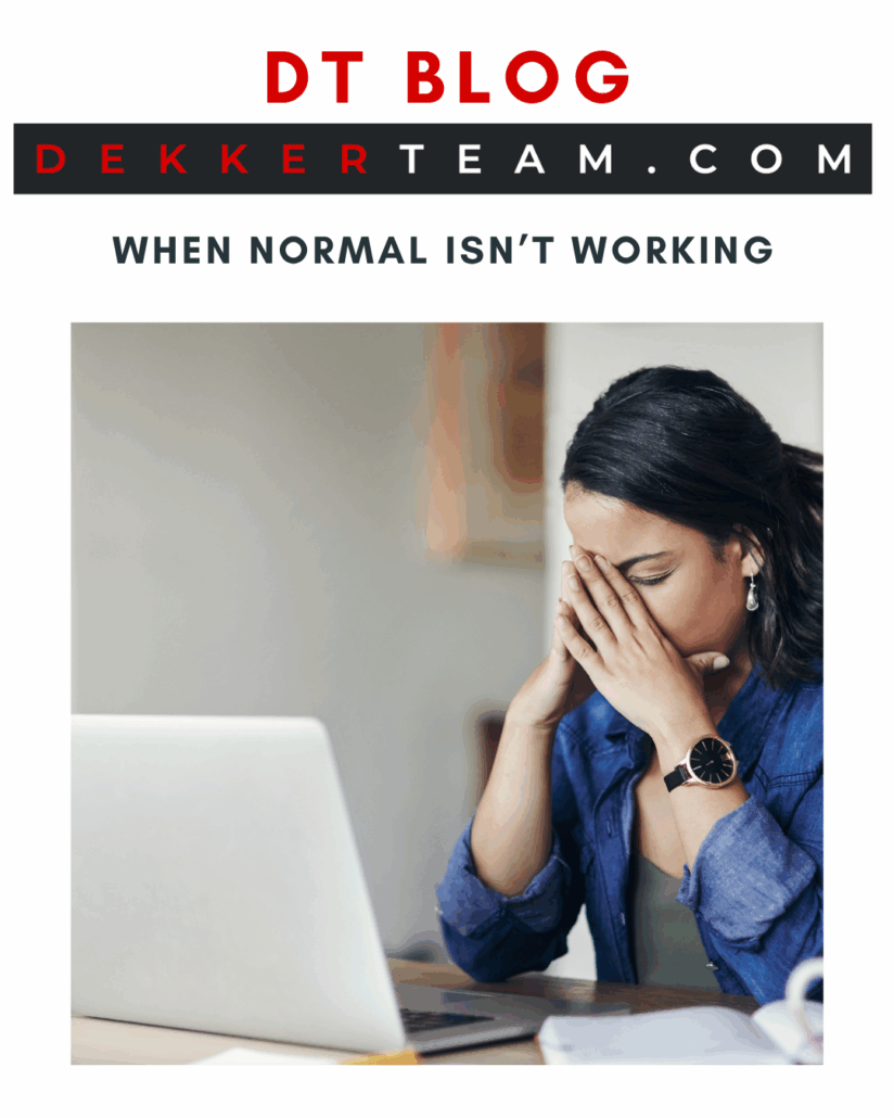 A woman sits at her desk with her laptop open, holding her face in her hands in exhaustion. The image reflects the frustration and overwhelm many Canadians feel when “normal” spending habits and debt cycles fail to create peace or progress.